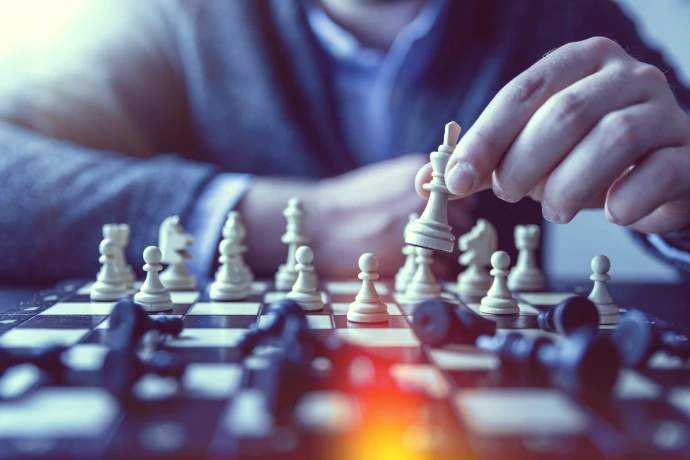 depth of field photography of man playing chess